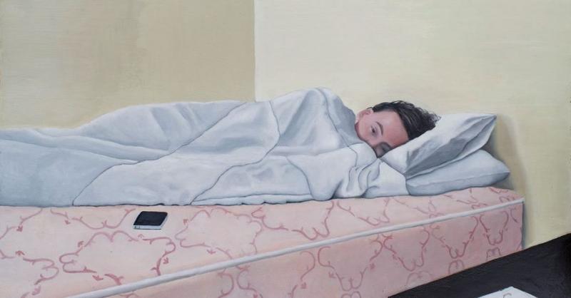 Person lying on a pink mattress under a blanket